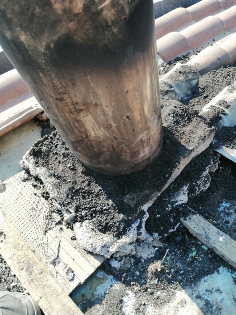 ERRATA INSTALLAZIONE, CON MATERIALE COMBUSTIBILE NELLE VICINANZE DELLA CANNA FUMARIA, MANCANZA DI ISOLAMENTO E COMIGNOLO (NON IN FOTO) FUORI NORMA